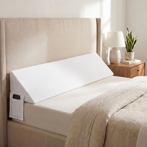 Drayvorx AirWedge white wedge pillow tucked between mattress and headboard, full bed width